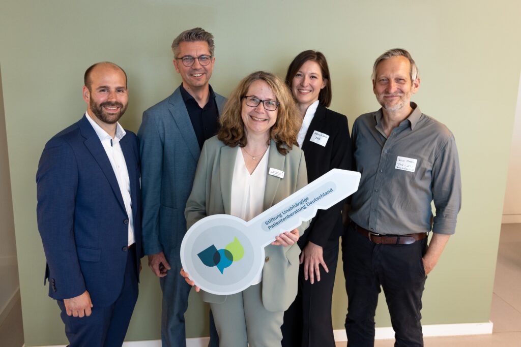Das Foto zeigt die feierliche Eröffnung der Beratungsstelle Berlin mit Schlüsselübergabe: Die beiden Vorstandsmitglieder der Stiftung UPD Sven Arndt (2.v.l.) und Dr. Katharina Graffmann-Weschke (m.) mit Florian Schönberg vom SoVD (l.), Melanie Störer vom Bundesministerium für Gesundheit (2.v.r) und Rainer Sbrzesny von der Geschäftsstelle des Patientenbeauftragten (r.)